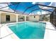 The pool is surrounded by a screen enclosure, patio, and glimpses of the house's interior and backyard at 18111 Lake Worth Blvd, Port Charlotte, FL 33948