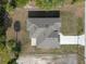Aerial view of the house shows the roof, driveway, and surrounding vegetation at 19092 Woodbine Ave, Port Charlotte, FL 33954