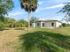 Backyard with lush green grass, a large palm tree, and a partial view of the home at 19092 Woodbine Ave, Port Charlotte, FL 33954