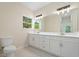 Bright bathroom features a double sink vanity with modern fixtures and a window view at 19092 Woodbine Ave, Port Charlotte, FL 33954