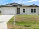 Charming single-Gathering home with a two-car garage and well-manicured lawn on a sunny day at 19092 Woodbine Ave, Port Charlotte, FL 33954