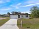 Front exterior view of the home showing the driveway and landscaping at 19092 Woodbine Ave, Port Charlotte, FL 33954