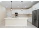 Stylish kitchen featuring an island, stainless steel appliances, pendant lights, and ample storage at 19092 Woodbine Ave, Port Charlotte, FL 33954