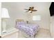 Cozy bedroom features a floral bed set, ceiling fan, and lots of light from the large window at 211 E Tarpon Nw Blvd, Port Charlotte, FL 33952