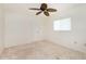 Unfurnished carpeted bedroom with a ceiling fan, window, and a single door at 211 E Tarpon Nw Blvd, Port Charlotte, FL 33952