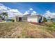 Charming single-story home with well-maintained lawn and lush landscaping, featuring modern solar panels at 211 E Tarpon Nw Blvd, Port Charlotte, FL 33952