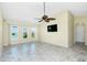 Bright living room features tiled floors, a ceiling fan, and ample natural light from multiple windows at 211 E Tarpon Nw Blvd, Port Charlotte, FL 33952