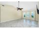 Spacious living room with tile flooring, ceiling fan, and bright natural light from the multiple windows at 211 E Tarpon Nw Blvd, Port Charlotte, FL 33952