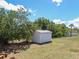 Backyard features a white storage shed nestled among lush trees and greenery at 2142 Gerard Ct, Port Charlotte, FL 33952