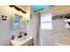 Cozy bathroom features a modern vanity, decorative mirror, and tiled shower with blue accents at 2142 Gerard Ct, Port Charlotte, FL 33952
