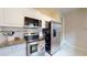 Well-lit kitchen features stainless steel appliances, granite countertops, and white cabinets at 2142 Gerard Ct, Port Charlotte, FL 33952