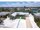 Aerial view of a waterfront home, showcasing the manicured lawn, palm trees, and a large driveway at 21812 Edgewater Dr, Port Charlotte, FL 33952