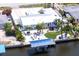 An aerial shot showcases the well-kept lawn, multiple seating areas, and a boat dock on the water at 21812 Edgewater Dr, Port Charlotte, FL 33952