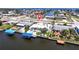Aerial view of a waterfront home, showcasing lush landscaping, boat dock, and expansive water views at 21812 Edgewater Dr, Port Charlotte, FL 33952