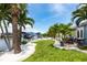 Picturesque backyard with vibrant greenery, palm trees, seating, and canal views at 21812 Edgewater Dr, Port Charlotte, FL 33952