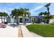 Inviting backyard with patio, lush lawn, palm trees, and blue house at 21812 Edgewater Dr, Port Charlotte, FL 33952