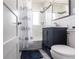Compact bathroom featuring a shower/tub combo with a shower curtain, navy blue vanity and tiled walls at 21812 Edgewater Dr, Port Charlotte, FL 33952