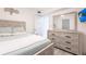 Cozy bedroom features a light wood bed frame and dresser, plus a decorative starfish on the wall at 21812 Edgewater Dr, Port Charlotte, FL 33952