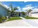 Inviting single-story home with lush front lawn, manicured landscaping, and a charming blue exterior at 21812 Edgewater Dr, Port Charlotte, FL 33952