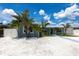 Cozy single-story home featuring well-kept landscaping, a light blue exterior, and bright blue skies at 21812 Edgewater Dr, Port Charlotte, FL 33952