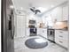 Modern kitchen featuring white cabinets, stainless steel appliances, and a round patterned rug at 21812 Edgewater Dr, Port Charlotte, FL 33952