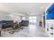 Inviting living room featuring a gray sofa, ceiling fan, hardwood floors, and entertainment center at 21812 Edgewater Dr, Port Charlotte, FL 33952