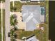 A stunning aerial view of a home featuring a pool, gray roof, landscaping, and waterfront access at 233 Beeney Se Rd, Port Charlotte, FL 33952