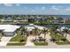 Aerial shot of a home near the water, showcasing a light-colored roof and tropical palm trees at 233 Beeney Se Rd, Port Charlotte, FL 33952