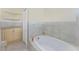 Well-lit bathroom showcasing a tub, vanity and glass shelving at 233 Beeney Se Rd, Port Charlotte, FL 33952