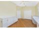 Bedroom with hardwood floors, built in cabinetry, a ceiling fan, and two closets at 233 Beeney Se Rd, Port Charlotte, FL 33952