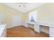 Bedroom showcasing hardwood floors, built-in desk with drawers, and double door closet at 233 Beeney Se Rd, Port Charlotte, FL 33952