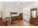 Bedroom features hardwood floors, ceiling fan, large window, and an ornate wooden bed frame with matching furniture at 233 Beeney Se Rd, Port Charlotte, FL 33952