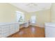 Bright bedroom featuring hardwood floors, built-in desk, and natural light at 233 Beeney Se Rd, Port Charlotte, FL 33952