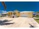 A beautiful yellow home with a two-car garage and carefully designed landscaping at 233 Beeney Se Rd, Port Charlotte, FL 33952