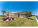 Beautiful waterfront home with screened-in lanai and lovely landscaping on a sunny day at 233 Beeney Se Rd, Port Charlotte, FL 33952