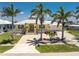 Charming yellow single-story home featuring a well-manicured lawn, palm trees, and inviting curb appeal at 233 Beeney Se Rd, Port Charlotte, FL 33952