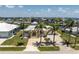 Inviting single-story yellow home with a well-manicured lawn and a driveway, enhanced by swaying palm trees at 233 Beeney Se Rd, Port Charlotte, FL 33952