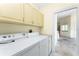 Spacious laundry room with ample cabinetry and counter space, including a washer and dryer set at 233 Beeney Se Rd, Port Charlotte, FL 33952