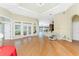 Hardwood living room with white trim, skylights, and glass doors offering scenic views at 233 Beeney Se Rd, Port Charlotte, FL 33952