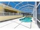 Backyard view showcasing the pool, screened-in lanai, and well-maintained exterior of the home at 233 Beeney Se Rd, Port Charlotte, FL 33952