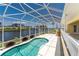 Private pool enclosed in a screened lanai, providing a serene setting with water views and lush landscaping at 233 Beeney Se Rd, Port Charlotte, FL 33952