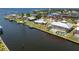 Picture of a yellow waterfront home with a large screened-in patio, a pool, and lush landscaping at 233 Beeney Se Rd, Port Charlotte, FL 33952