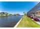 Scenic waterfront with lush lawn leads to the screened lanai and home at 233 Beeney Se Rd, Port Charlotte, FL 33952