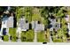 Birds eye view displays residential properties with lawns, mature trees, and cars, surrounded by greenery at 23476 Harper Ave, Punta Gorda, FL 33980
