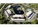 Aerial view of a community featuring a picturesque pond, swimming pool, tennis court, and attractive buildings at 23476 Harper Ave, Punta Gorda, FL 33980