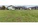 Large grassy backyard featuring a home with a screened in patio and landscaping at 26177 Madras Ct, Punta Gorda, FL 33983