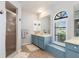 Bright bathroom featuring a glass enclosed shower, and blue vanity with access to the exterior at 26177 Madras Ct, Punta Gorda, FL 33983