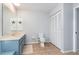 Neutral-toned bathroom with a blue vanity, tiled floor, and a large linen closet at 26177 Madras Ct, Punta Gorda, FL 33983