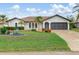 Charming single-story home with well-manicured lawn and tropical landscaping, enhancing curb appeal at 26177 Madras Ct, Punta Gorda, FL 33983