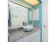 Bright bathroom featuring a granite countertop, vessel sink, ample cabinet space, and modern fixtures at 279 Mariner Ln, Rotonda West, FL 33947